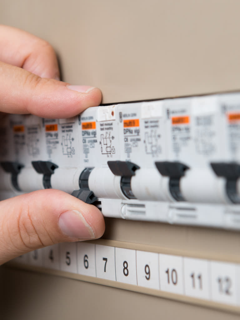 Electrician working inside an electrical panel