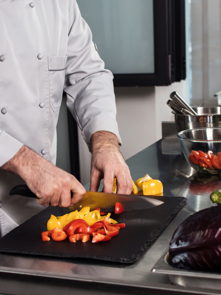 Cook working a knife on the prep line